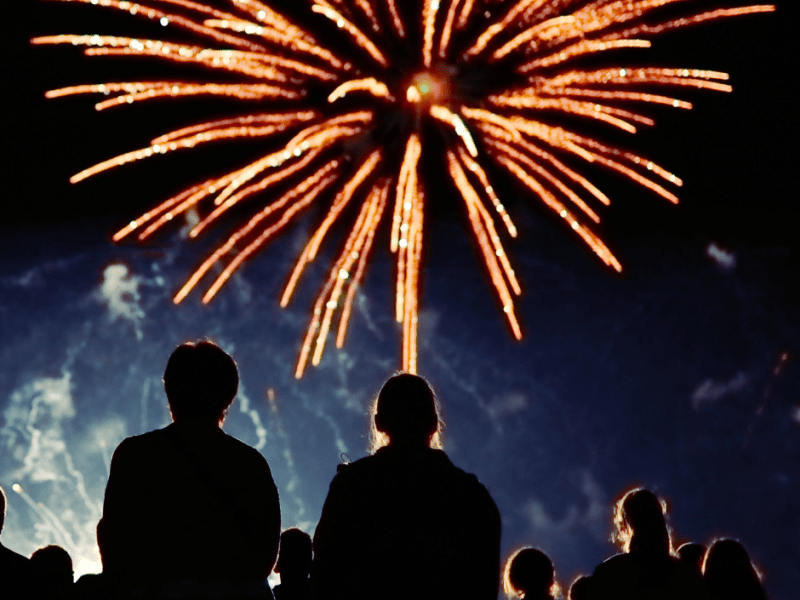 Mensen kijken naar siervuurwerk in de lucht