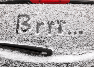 Besneeuwde autoruit met tekst 'Brrr..'
